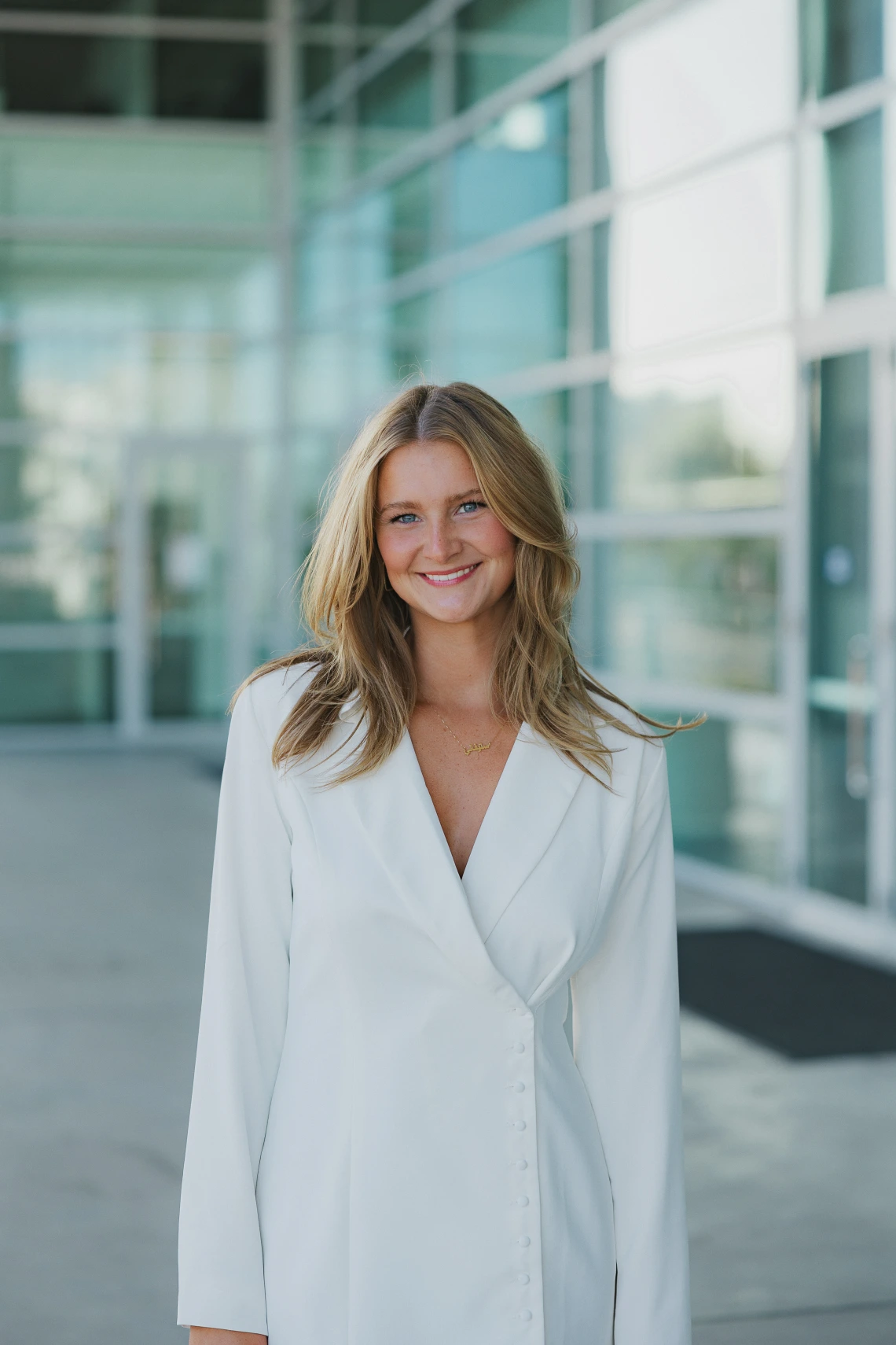 girl smiling wearing a white blazer with blonde hair