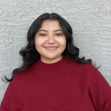 Student wearing a red sweater and smiling